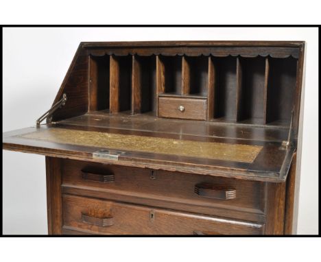 A 1930's Art Deco oak bureau desk raised on ball feet with a bank of drawers under a fall front bureau top above.&nbsp;Measur