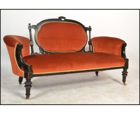 A Victorian mahogany aesthetic movement loving sofa - chesterfield settee. Ebonised with gilt decoration being raised on turn