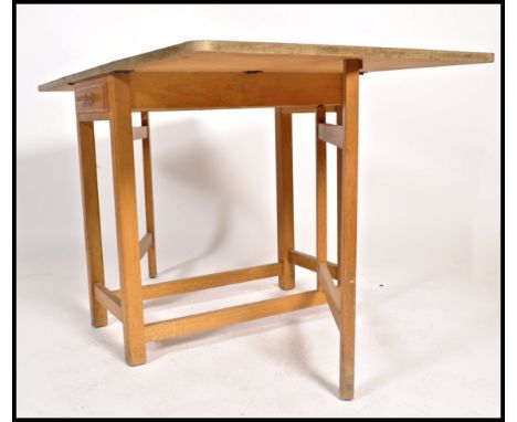 A retro 1950's red formica and beech wood drop leaf harvest table. The red formica top raised on gate leg action with cutlery