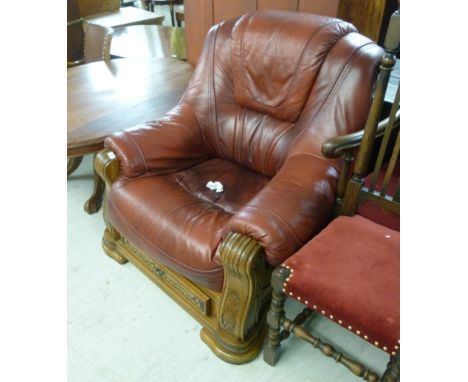 A modern oak showwood framed armchair, upholstered in oxblood coloured hide, over a drawer and bracket underframe          BS