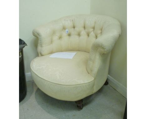 A late Victorian tub chair, having a horseshoe shaped back, part button upholstered in cream coloured, floral fabric, raised 