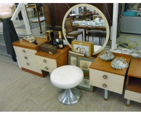 A 1970s teak finished and melamine dressing table, surmounted by a large circular mirror, over opposing two drawer cabinets, 