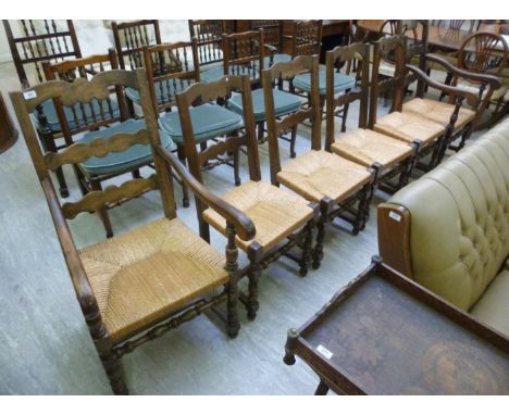 A set of six 1920s style oak framed ladder back dining chairs, the rush seats raised on turned and block legs  comprising fou