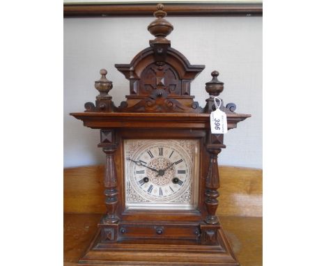 A HARDWOOD MANTLE CLOCK WITH PODGER TOP 2 CARVED COLOMNS, GILDED DIAL WITH ROMAN NUMERALS, BEADED GLASS, STRIKING ON A SPRING