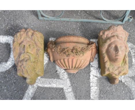 Pair of terracotta wall pockets or rain hoppers modelled as a male and female mask, 45cm high, together with a Neo-classical-