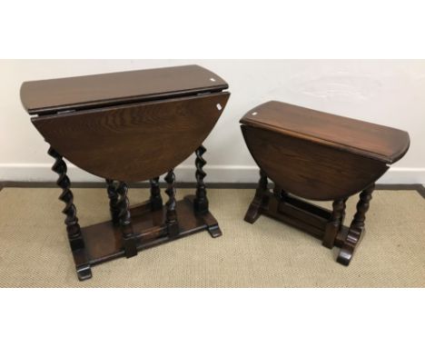 A 20th Century oak oval gate leg drop leaf tea table in the 17th Century style raised on barley twist supports united by a pl