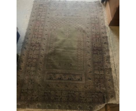 A Ghiordes prayer rug, the central panel set with mihrab design with green ground within a stepped floral decorated beige, bl