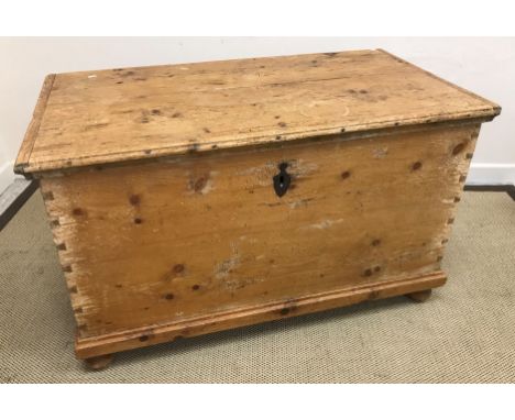 A Victorian pine trunk, the plank top with cleated ends and moulded front edge opening to reveal a candle box raised on bun f