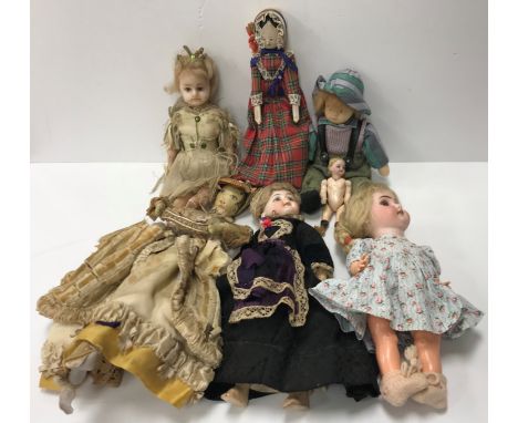 An early 20th Century doll with painted face in 18th Century style clothing, a wax doll with blue glass eyes dressed as a fai