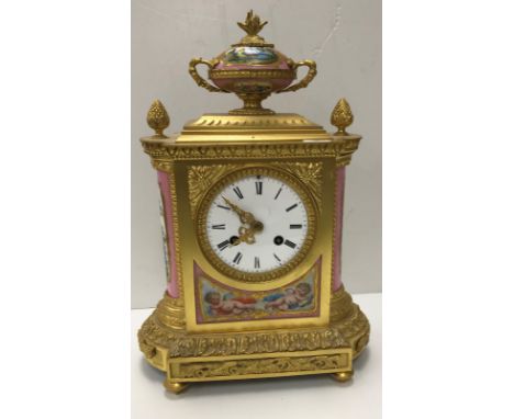 A 19th Century French gilt brassed cased mantle clock with Sèvres style pink ground panels decorated with cherubs and exotic 