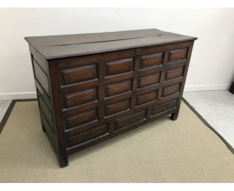 An 18th Century Welsh oak mule chest, the plain rising top with moulded edge, over a fielded panelled front with twelve panel
