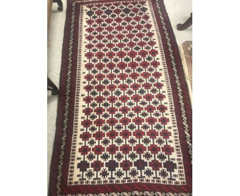 A Persian carpet, the central panel set with repeating lozenge decoration on a dark blue ground with stylised tarantula motif