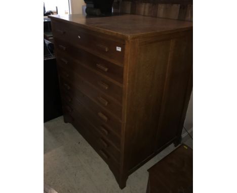 An early 20th Century oak plan or folio chest, the plain top above eight drawers with lug handles raised on bracket feet 114 