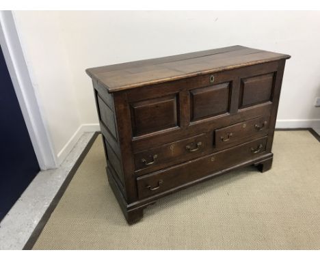 An 18th Century oak mule chest, the plain top with moulded edge over three fielded panels and two short over one long drawer 