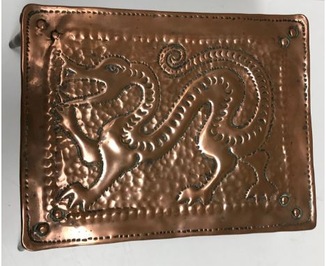 A Newlyn School copper and brass trivet by John Pearson, the top decorated with a dragon raised on four splayed legs, bears i