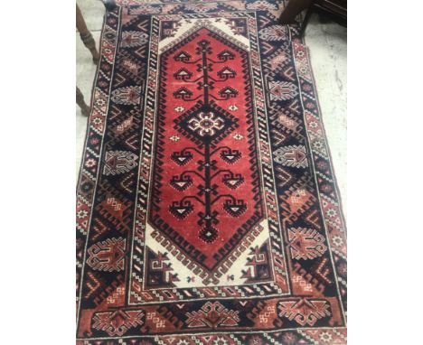 A Persian carpet, the central panel set with elongated lozenge medallion on a cream ground within a stepped red, blue and cre