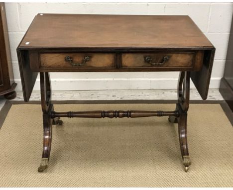 A 20th Century mahogany drop leaf sofa table in the George III taste on lyre end supports to splayed legs united by a centre 