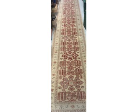 An Afghan Ziegler style runner, the central panel set with repeating stylised foliate pattern on a cream ground within a crea