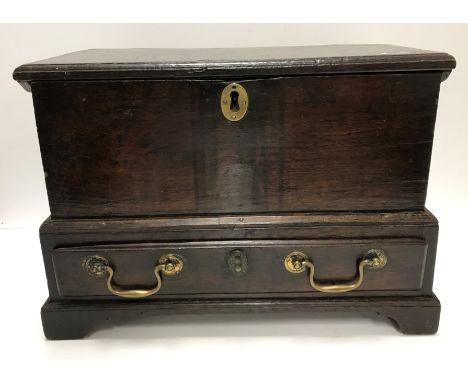 A rare mid 18th Century child's oak coffer bach, the single piece top with moulded edge over plain side panels and a single d