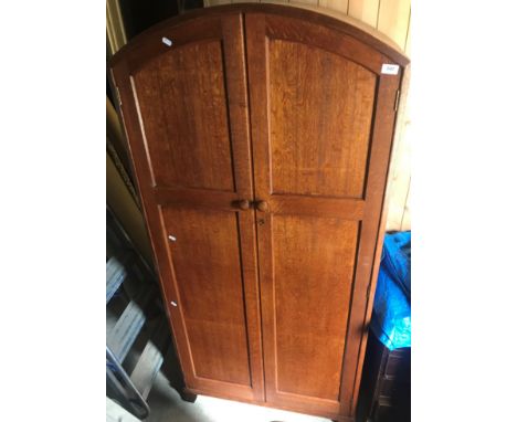 A circa 1928 Heals oak wardrobe in the Arts &amp; Crafts taste, the domed top above four plain panels with chamfered stiles o