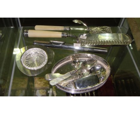 Shelf of assorted silver plated ware including crumb scoop, tongs, scent bottle etc.