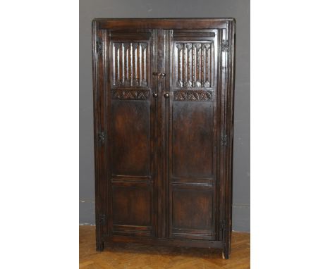 A reproduction oak linenfold panel double wardrobe with internal mirror door and twin suit hanging rails, 183 x 106 x 51cm