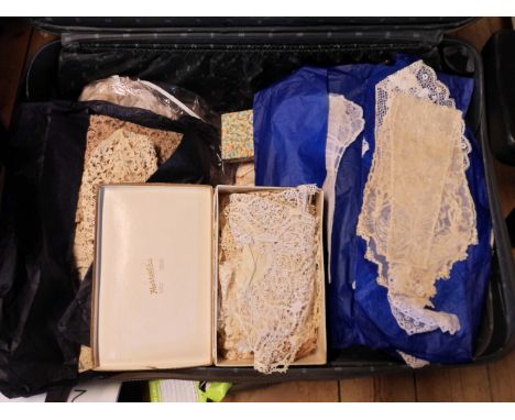 A suitcase containing a large quantity of lace, textiles, etc.