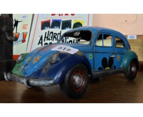 A modern painted tin Hippy VW Beetle model