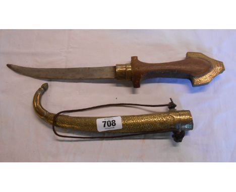 An Eastern curved dagger with wooden handle and decorative chaste brass scabbard