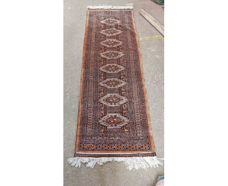A handmade runner with repeat guls and geometric border