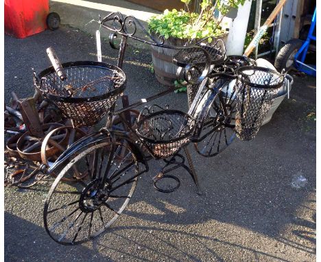A decorative wrought iron garden planter in the form of a bicycle with black painted finish