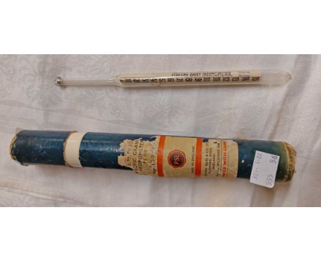 A vintage glass floating dairy thermometer contained in associated card tube