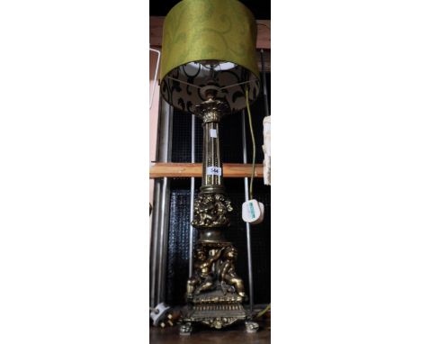 A tall cast brass table lamp of column form with putti decoration