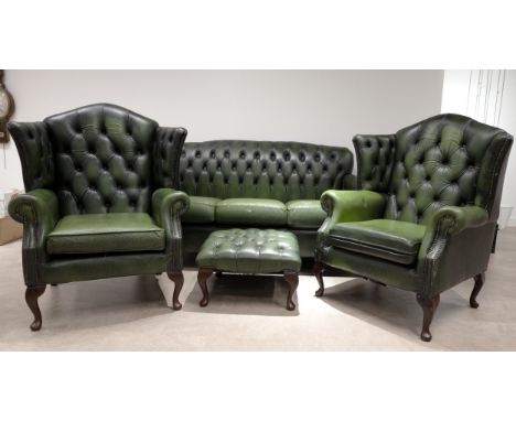 Four piece green&nbsp; leather button back Chesterfield lounge suite, comprising sofa, two wingback elbow chairs and footstoo