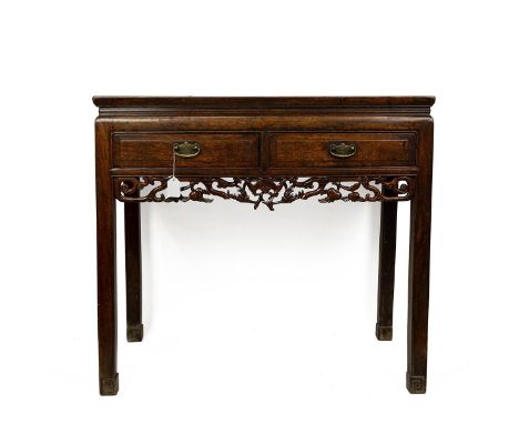 Chinese hardwood two drawer console table with open carved fretwork skirt raised on square supports to spade feet. L93cm x D4