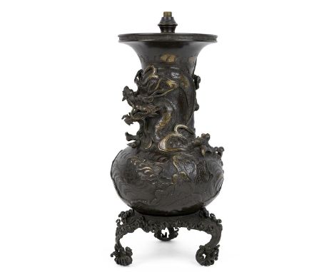 A finely detailed Japanese bronze lamp base decorated with a three toed Cloud Dragon and clouds sat on a tripod detachable ba