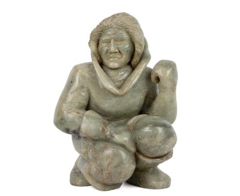 A large Inuit Eskimo Jade carving of a crouching man. One hand poised as if holding a spear or similar, signed to outer foot 