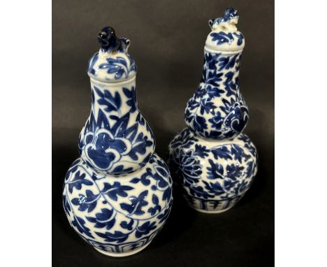 A pair of 19th century Chinese gourd shaped blue and white porcelain vases and covers with trailing floral detail 