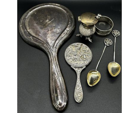 A quantity of silver including a hand mirror, napkin ring, two souvenir spoons, thistle salt pot and a small Danish mirror 