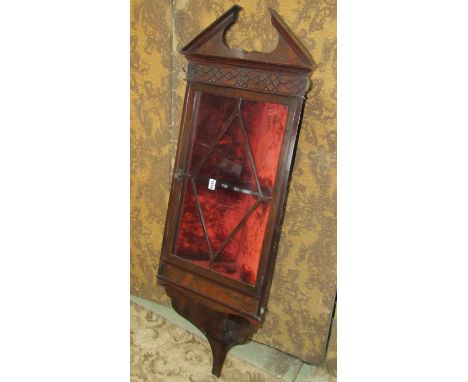 An Edwardian rosewood hanging corner cabinet in the Georgian style, with broken architectural arched pediment over a glazed p