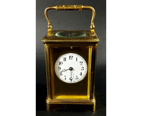 A 19th century French carriage clock with enamelled dial and eight day striking movement, currently running 