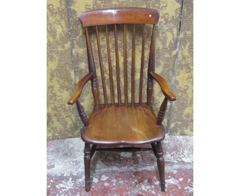 A mid 19th century Windsor stick back elbow chair principally in elm and beechwood 