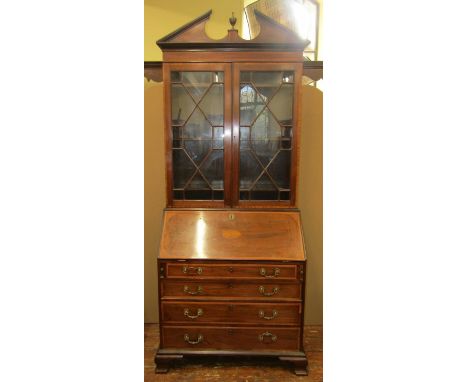 A Georgian mahogany bureau bookcase of four long graduated drawers, the fall flap enclosing a fitted interior, the bookcase w