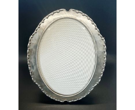 An Edwardian oval silver picture frame, glazed with a silk back, Birmingham 1907, H.W. Ltd for Henry Wilkinson, 20cm x 15cm a