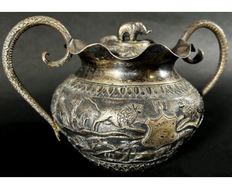 A middle eastern silver metal bowl with cover and serpent handles decorated with lions, gazelles and an elephant finial and a