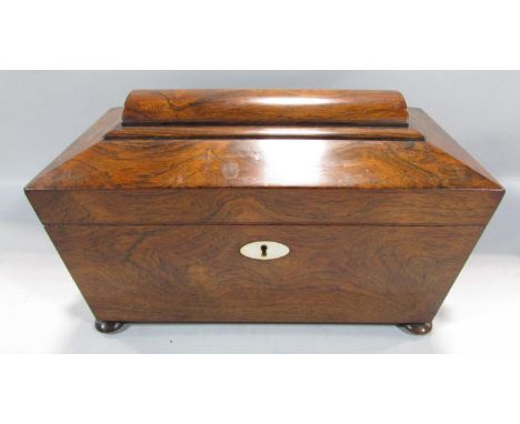 A Regency rosewood sarcophagus tea caddy with a glass mixing bowl flanked by two caddies, wooden ring handles, 34cm wide x 21