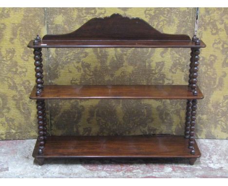 A 19th century rosewood wall shelf on three graduated rectangular tiers raised on turned bobbin supports, 66cm high x 76cm wi