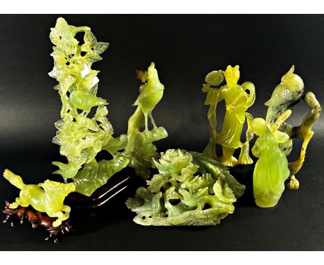 A collection of Chinese pale celadon coloured bowenite jade carvings to include a pierced group detailing a bird amongst foli