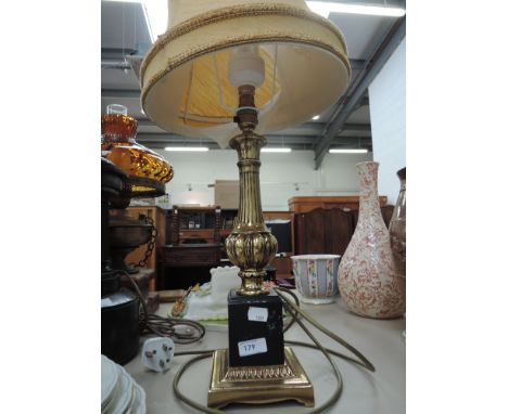A modern brass effect lamp with shade