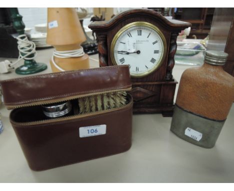 A leather cased gentlemans vanity set, treen mantle clock by John Bennet Ltd of London and hip flask